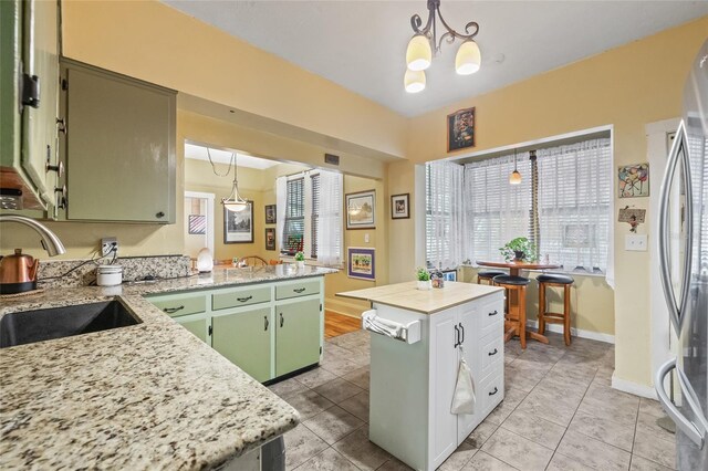 916 E Broad St, Tampa, FL 33604 - kitchen with green cabinets, a sink, freestanding refrigerator, and healthy amount of natural light