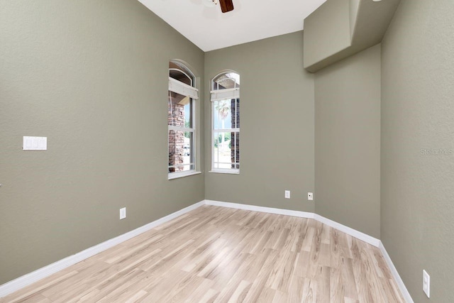 unfurnished room featuring light wood finished floors, a ceiling fan, a textured wall, and baseboards
