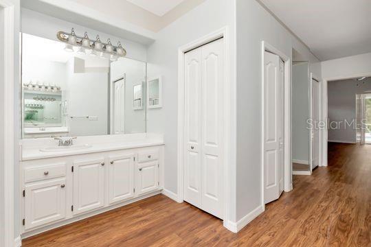 bathroom with wood finished floors, vanity, and baseboards