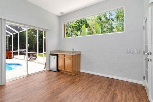 bar featuring wood finished floors and baseboards