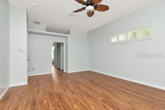 empty room featuring ceiling fan, wood finished floors, and baseboards