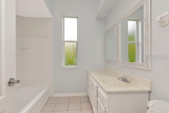 bathroom featuring tile patterned flooring, vanity, toilet, shower / bathtub combination, and baseboards