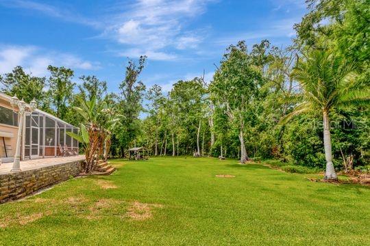view of grassy yard with glass enclosure