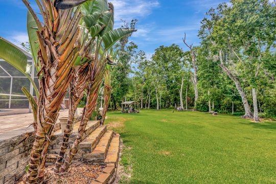 view of green lawn with a lanai
