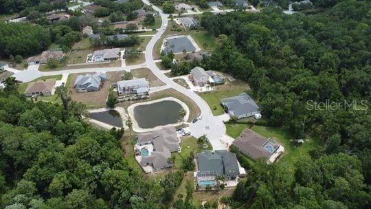 aerial view of property and surrounding area featuring a heavily wooded area
