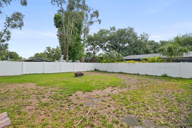 fenced backyard featuring a fire pit