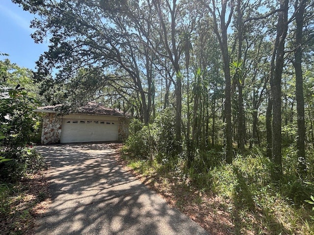 2995 N Bravo Dr, Beverly Hills, FL 34465 - view of front of house with stone siding, a garage, and driveway