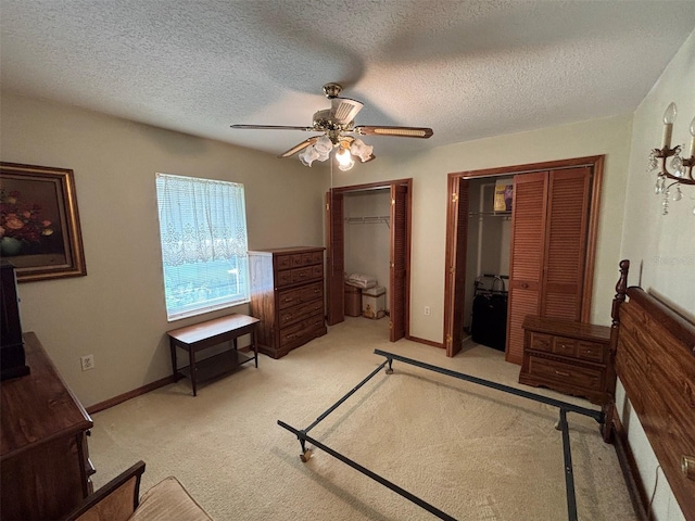 2995 N Bravo Dr, Beverly Hills, FL 34465 - bedroom featuring multiple closets, light carpet, ceiling fan, baseboards, and a textured ceiling