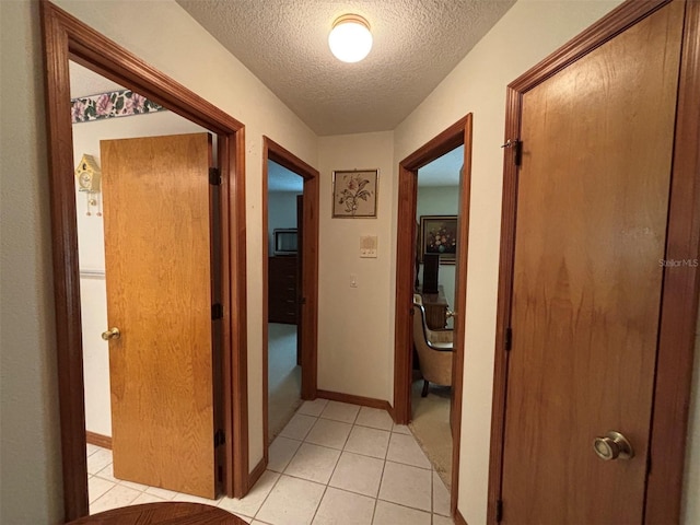 2995 N Bravo Dr, Beverly Hills, FL 34465 - hall featuring a textured ceiling, light tile patterned floors, and baseboards