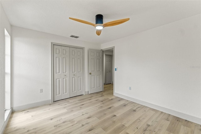 7400 Belvedere Ter, New Port Richey, FL 34655 - unfurnished bedroom featuring light wood-style floors, baseboards, a closet, and ceiling fan