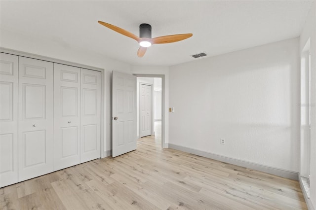 7400 Belvedere Ter, New Port Richey, FL 34655 - unfurnished bedroom featuring wood finished floors, baseboards, a closet, and a ceiling fan