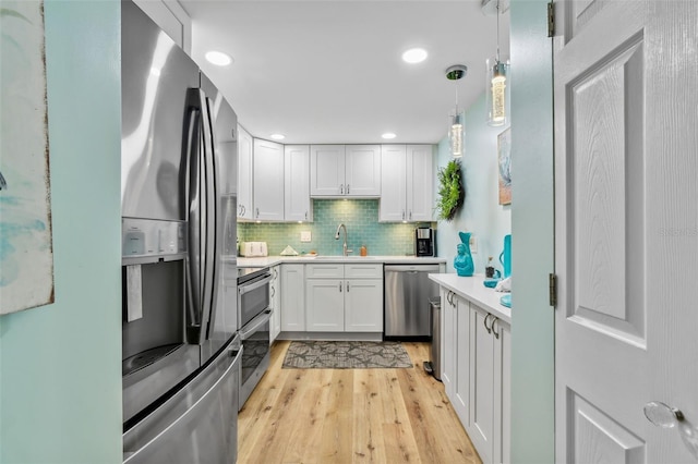 10216 Regal Dr Unit 310, Largo, FL 33774 - kitchen featuring stainless steel appliances, a sink, light countertops, light wood finished floors, and tasteful backsplash
