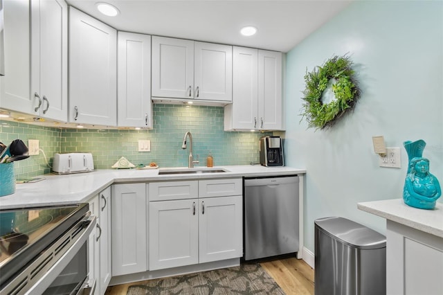 10216 Regal Dr Unit 310, Largo, FL 33774 - kitchen with stainless steel appliances, a sink, light countertops, tasteful backsplash, and light wood-type flooring