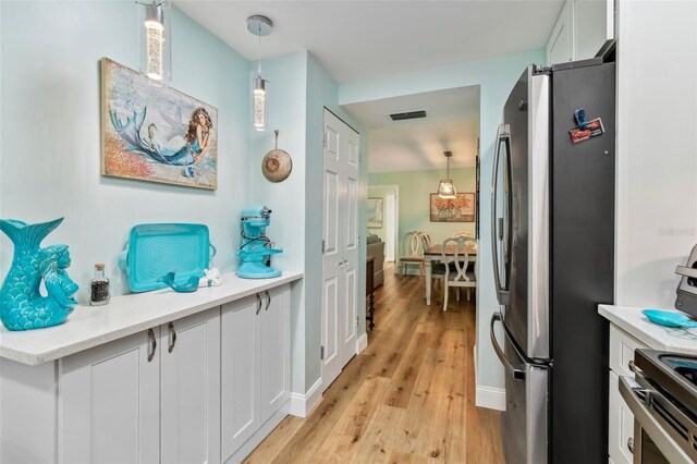 10216 Regal Dr Unit 310, Largo, FL 33774 - kitchen featuring freestanding refrigerator, light wood-style floors, range, light countertops, and white cabinets
