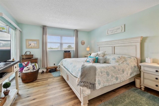 10216 Regal Dr Unit 310, Largo, FL 33774 - bedroom featuring multiple windows, light wood-style floors, and a textured ceiling
