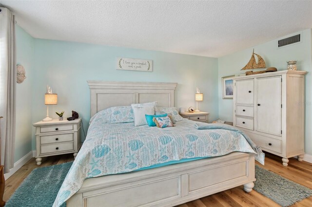 10216 Regal Dr Unit 310, Largo, FL 33774 - bedroom featuring wood finished floors, a textured ceiling, and baseboards