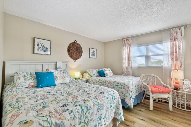10216 Regal Dr Unit 310, Largo, FL 33774 - bedroom featuring light wood-style flooring and a textured ceiling