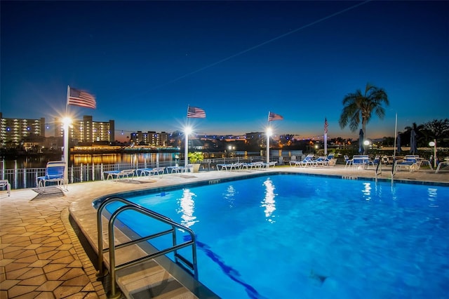 10216 Regal Dr Unit 310, Largo, FL 33774 - pool at night featuring a patio area, a community pool, fence, and a water view