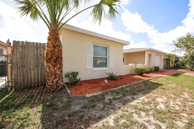 9816 Crofton Ln, Port Richey, FL 34668 - view of home's exterior with stucco siding, fence, and an attached garage