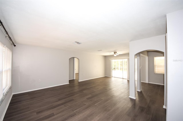 9816 Crofton Ln, Port Richey, FL 34668 - unfurnished room featuring arched walkways, dark wood finished floors, ceiling fan, and baseboards
