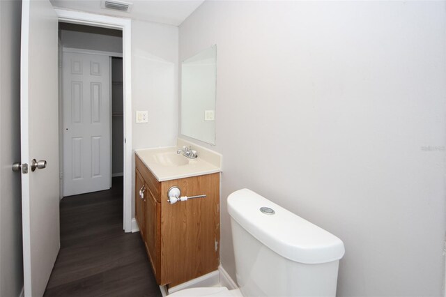 9816 Crofton Ln, Port Richey, FL 34668 - half bath with vanity, wood finished floors, and toilet