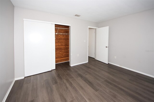 9816 Crofton Ln, Port Richey, FL 34668 - unfurnished bedroom with wood finished floors, baseboards, and a closet