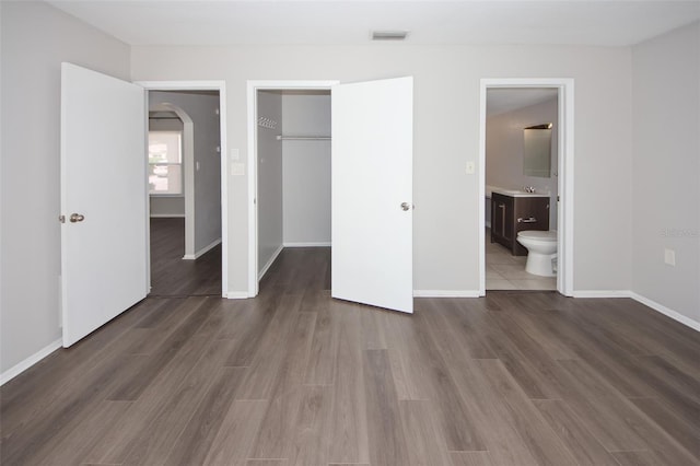 9816 Crofton Ln, Port Richey, FL 34668 - unfurnished bedroom featuring a sink, arched walkways, baseboards, and a closet