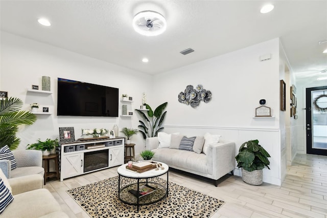 living area with light wood-type flooring and recessed lighting