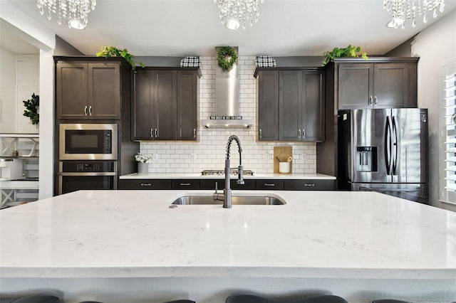 kitchen featuring appliances with stainless steel finishes, a chandelier, and a sink