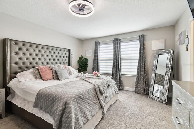 bedroom featuring light carpet and baseboards