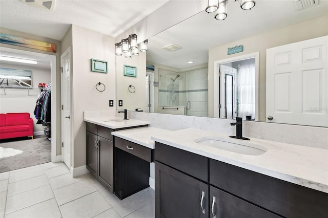 full bathroom with a shower stall, tile patterned floors, a walk in closet, vanity, and baseboards