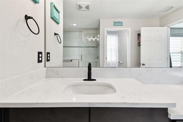 bathroom with a stall shower and vanity