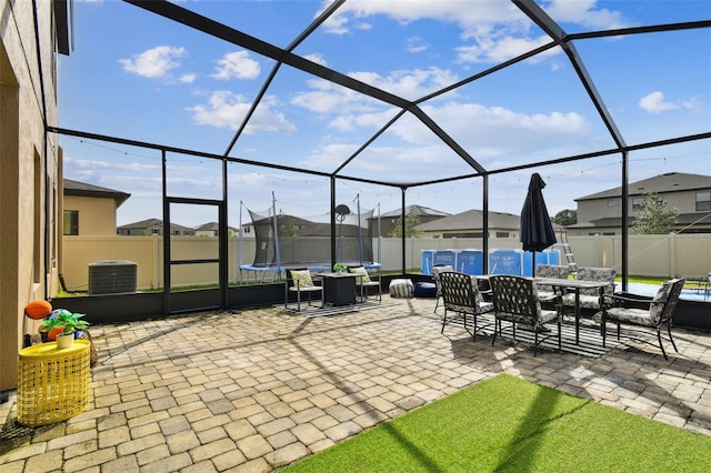 view of patio / terrace featuring a trampoline, outdoor dining space, a residential view, and a fenced backyard