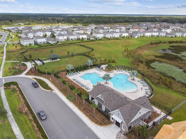 view of property location with a pool and nearby suburban area