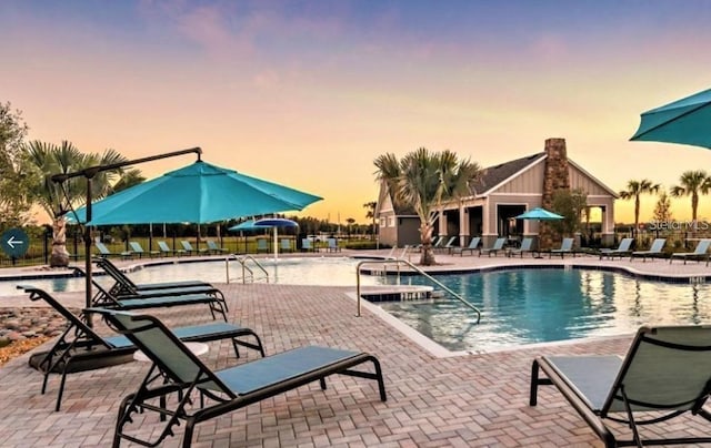 community pool with a patio and fence