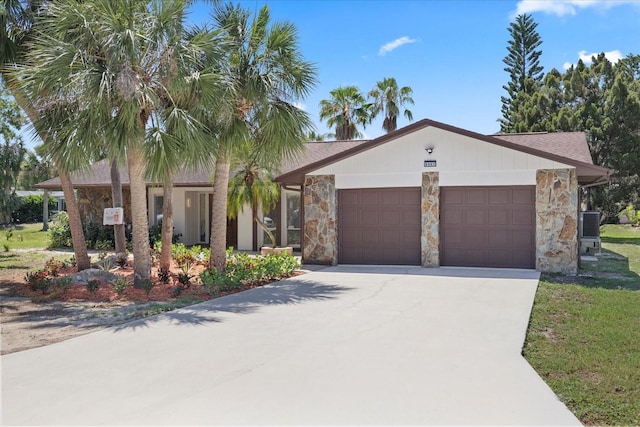 5507 Nimitz Rd, New Port Richey, FL 34652 - view of front of property featuring stone siding, a garage, and driveway