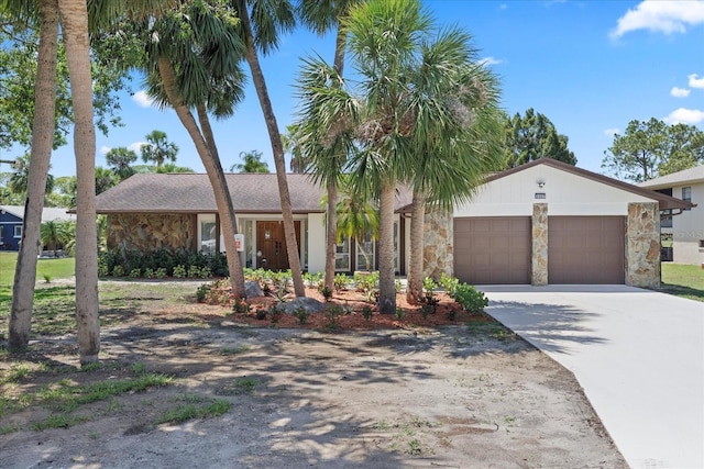 5507 Nimitz Rd, New Port Richey, FL 34652 - view of front facade featuring stone siding, a garage, and concrete driveway