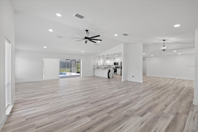 5507 Nimitz Rd, New Port Richey, FL 34652 - unfurnished living room with lofted ceiling, a chandelier, light wood finished floors, a ceiling fan, and recessed lighting