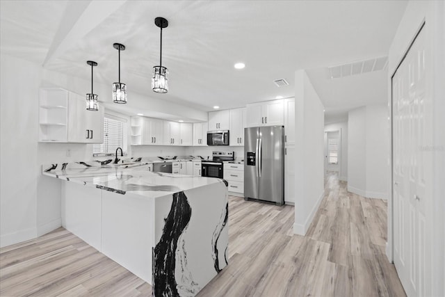 5507 Nimitz Rd, New Port Richey, FL 34652 - kitchen featuring stainless steel appliances, open shelves, a peninsula, white cabinets, and light wood-type flooring