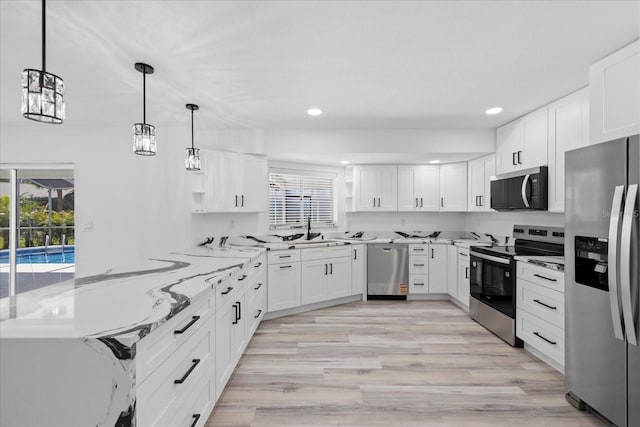 5507 Nimitz Rd, New Port Richey, FL 34652 - kitchen with stainless steel appliances, light stone countertops, white cabinetry, recessed lighting, and light wood-style flooring