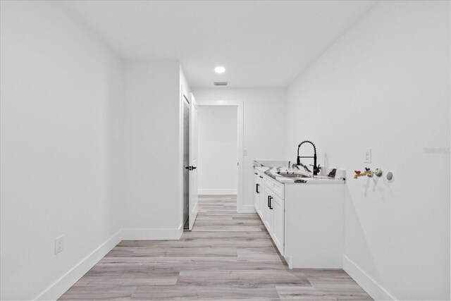 5507 Nimitz Rd, New Port Richey, FL 34652 - corridor featuring a sink, baseboards, light wood-style floors, and recessed lighting