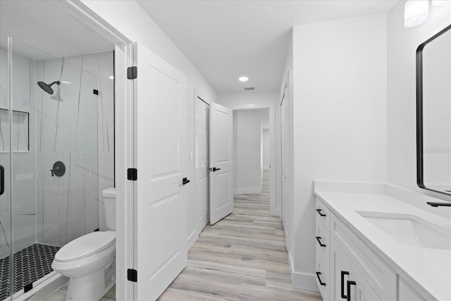 5507 Nimitz Rd, New Port Richey, FL 34652 - full bath featuring a shower stall, vanity, toilet, wood finished floors, and recessed lighting