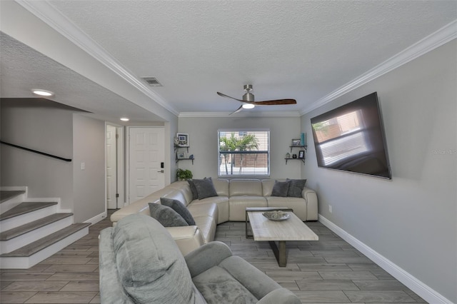 living area with a textured ceiling, wood tiled floors, ceiling fan, baseboards, and crown molding