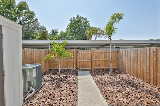 view of yard with central AC and fence