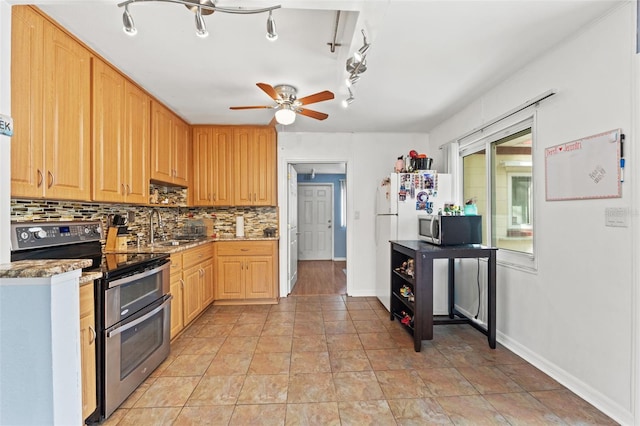 kitchen featuring stainless steel appliances, decorative backsplash, ceiling fan, a sink, and light brown cabinetry
