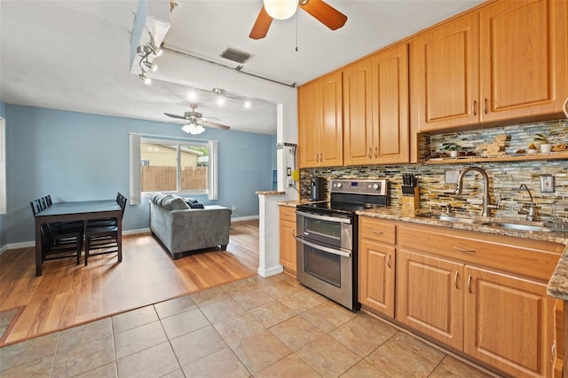 kitchen featuring double oven range, a ceiling fan, a sink, and tasteful backsplash