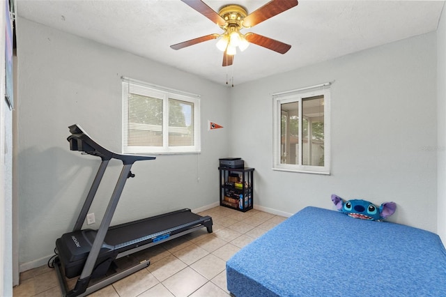exercise room featuring plenty of natural light, light tile patterned floors, and ceiling fan