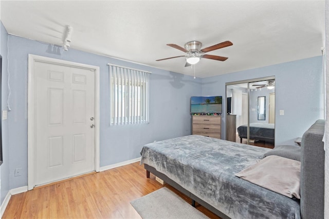 bedroom featuring baseboards, light wood-style flooring, and a closet