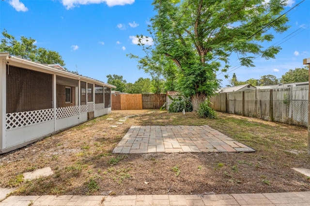fenced backyard with a sunroom and a patio