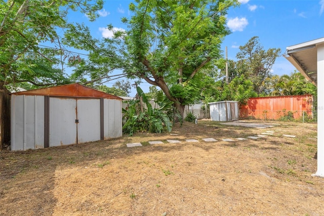 fenced backyard with a shed and an outbuilding